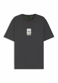 Camiseta de algodón gris con cuello redondo, que presenta un estampado gráfico central, incluyendo la palabra "BOSS" y acentos verdes. Mangas cortas.