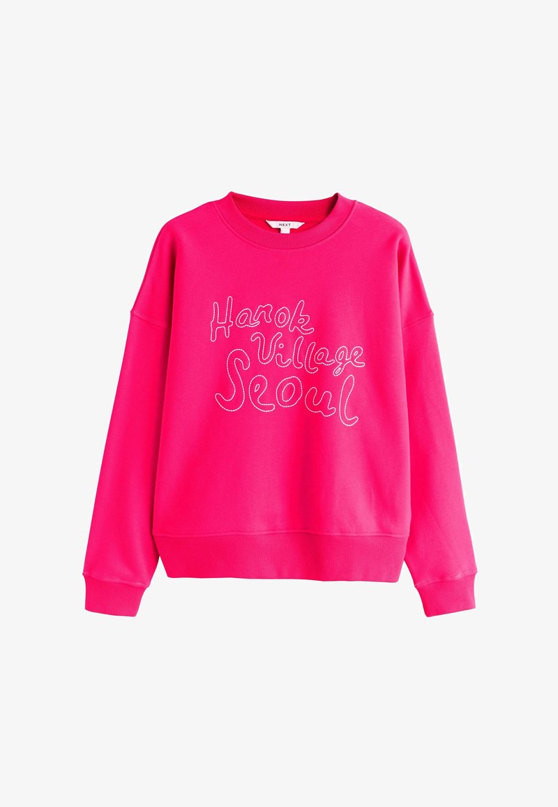 Sweatshirt à col rond rose vif avec un texte cursif blanc "Hanok Village Seoul" sur le devant, doté de manches longues et de poignets côtelés.