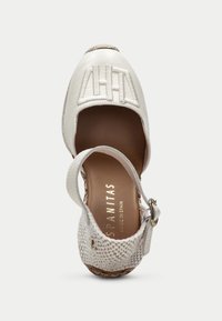 Bílé kožené espadrilky s otevřenými stranami, pletenými detaily a nastavitelným popruhem na kotníku. Mají texturovaný tkaný podpatek a embosované logo.