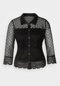 Blouse noire transparente à motif pois, avec détails en dentelle sur le corsage et les poignets, col à revers, et boutons dorés sur le devant.