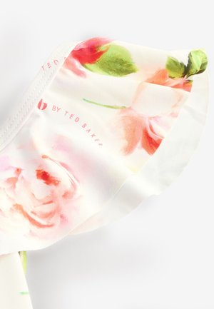 Tela con estampado floral en tonos de rosa, verde y blanco. Presenta una textura suave con un diseño fluido y delicado. Incluye el logotipo de la marca.