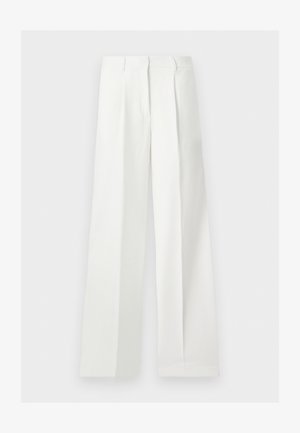 Pantalones blancos de talle alto, pierna ancha, confeccionados a medida con pliegues delanteros y cierre de cremallera oculto.