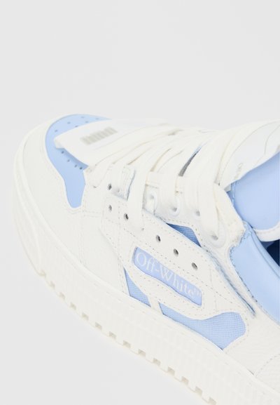 Bílé a modré tenisky s texturovaným koženým povrchem, obsahující výrazné logo Off-White, šněrovací design a vzorovanou podrážku.