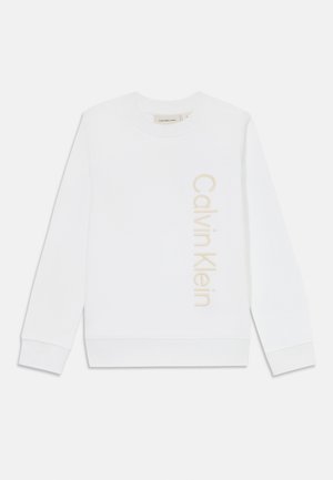 Biely sveter vyrobený z mäkkého bavlneného materiálu, s okrúhlym výstrihom, dlhými rukávmi a béžovým vertikálnym logom "Calvin Klein" na prednej strane.