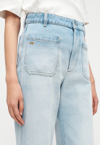 Φωτεινό γαλάζιο τζιν τζιν με ψηλή μέση, με ίσια γραμμή και ορατές ραφές. Διακριτικό λογότυπο 'VB' σε χρυσό στο πίσω τσεπάκι.