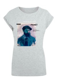 Lysgrå t-shirt med et print af et Monet-portræt i en blå og sort farveskala. Teksten inkluderer "MONET" og et citat i sort.