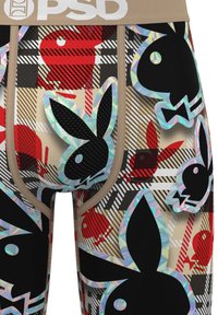 Close-up of boxer briefs with black and red Playboy bunny logos and geometric plaid pattern in beige, black, and red tones.