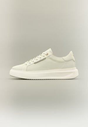 Weißer Sneaker mit niedrigem Schaft aus Canvas, vorn mit Schnürung, dicker Sohle und einem Metallschild mit der Aufschrift "REPLAY" an der Seite.