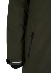 Chaqueta acolchada verde con un bolsillo negro con cremallera, puños elásticos y acentos reflectantes blancos en la manga y el bolsillo. Textura suave.