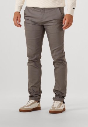 Grijze, slanke broek gemaakt van soepel stof; heeft een rechte voorkant, zijzakken en een elegant silhouet, gecombineerd met casual sneakers.