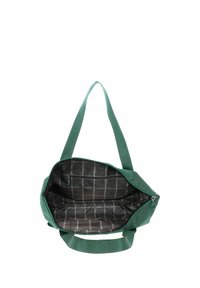 Sac fourre-tout en tissu vert avec fermeture éclair ouverte montrant une doublure intérieure noire spacieuse avec un motif de texte blanc vertical et une poche intérieure zippée.