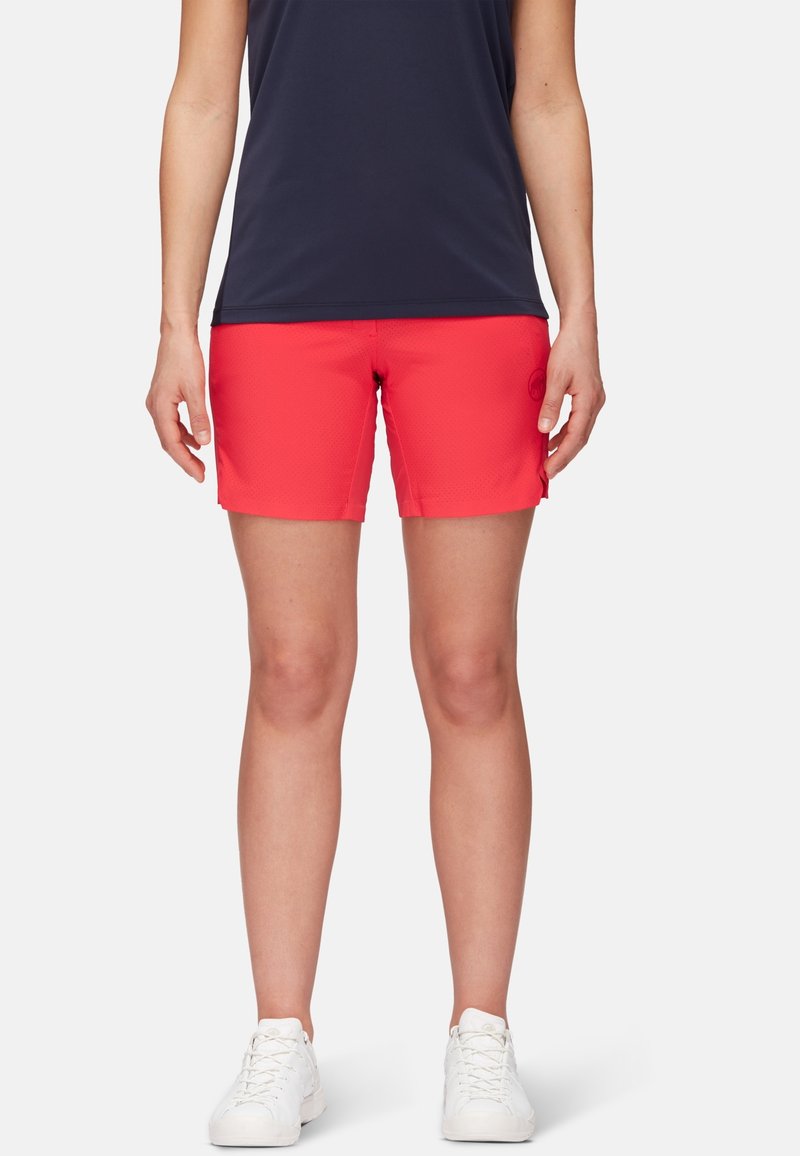 Red athletic shorts with a textured pattern, fitted design, and a slightly elastic waistband. Paired with a dark navy top and white sneakers.