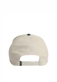 Cap with a light beige fabric, flat brim, adjustable plastic strap at the back, and a green button accent on top. Black logo tag on strap.