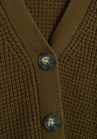 Gros plan d'un cardigan marron tricoté avec deux grands boutons ronds marbrés et un col en V côtelé.