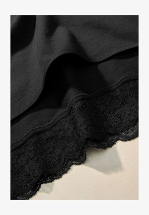 Fekete szövetfüggönyök sima textúrával, alul hullámos csipke szegéllyel. A csipke részletes mintázattal és áttetsző megjelenéssel rendelkezik.