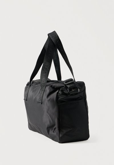 Μαύρη ορθογώνια τσάντα ώμου από μαλακό ύφασμα με μακριές λαβές με λογότυπο και κλείσιμο με φερμουάρ στην κορυφή, εμφανισμένη σε ελαφριά γωνία.