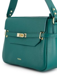 Teal tekstureret læderhåndtaske med guldfarvet hardware, en frontklaplukning, justerbar rem og lille "VENEZIA" logo i guldbogstaver.