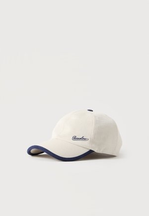 Casquette de baseball écrue avec bordure bleu marine sur la visière et logo "Borsalino" brodé sur le panneau avant.