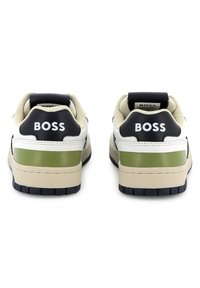 Baskets BOSS en blanc, noir et olive avec un col rembourré, une semelle en caoutchouc et des détails du logo sur le talon. Matériaux texturés.