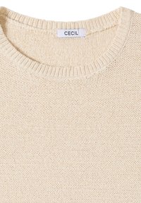 Pull en maille crème avec encolure ronde côtelée et étiquette blanche portant l'inscription "CECIL" cousue à l'intérieur du col.