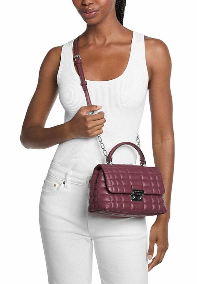 Borsa a tracolla borgogna trapuntata con catena e manico superiore. Caratterizzata da una chiusura a pattina con un accento metallico. Pelle testurizzata, design compatto.