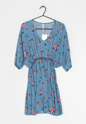 Blaues Blumenkleid mit rosa und roten Blumen, geraffter Taille und dreiviertel Ärmeln, das auf einem schwarzen Kleiderbügel vor weißem Hintergrund hängt.