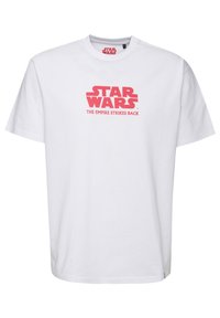 Bílá bavlněná trička s výrazným červeným designem, na kterém je na přední straně nápis "STAR WARS" a "IMPERIUM ÚTOČÍ". Standardní střih.
