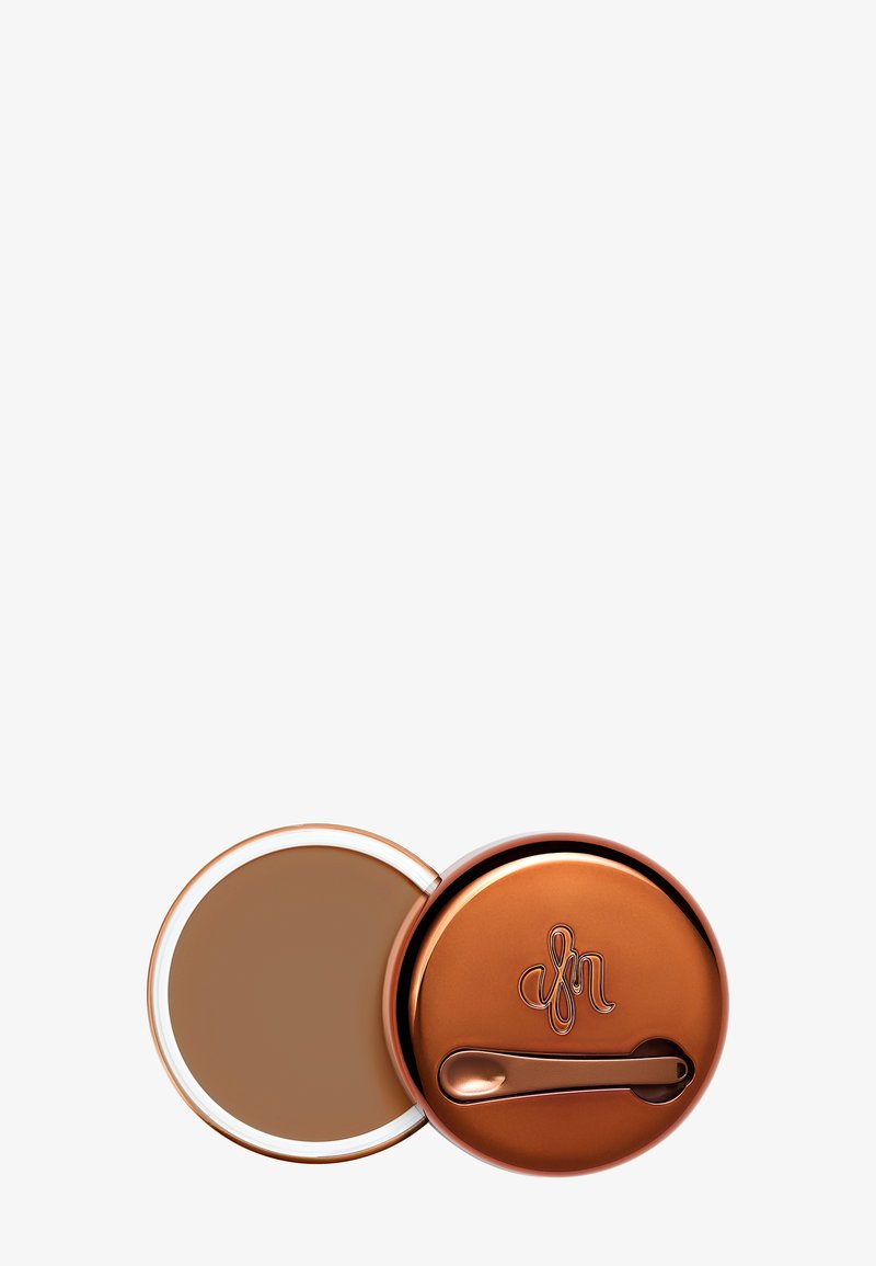 Compact de maquillage en bronze avec une crème lisse à l'intérieur. Dispose d'un extérieur brillant et d'une petite spatule pour l'application.