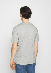Grå kortærmet T-shirt lavet af blødt stof, med rund hals og en afslappet pasform, med synlige sømme og et afslappet design.