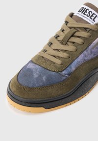 Αθλητικό παπούτσι σε χρώμα ελιάς και μπλε σουέντ με ταμπά κορδόνια, μαύρη ενδιάμε�ση σόλα, σόλα από καουτσούκ και λογότυπο Diesel στη γλώσσα του παπουτσιού.