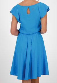 Vestido azul con mangas cortas de volantito, diseño de espalda con abertura en forma de clave y cinturilla elástica, hecho de una tela ligera y suave.