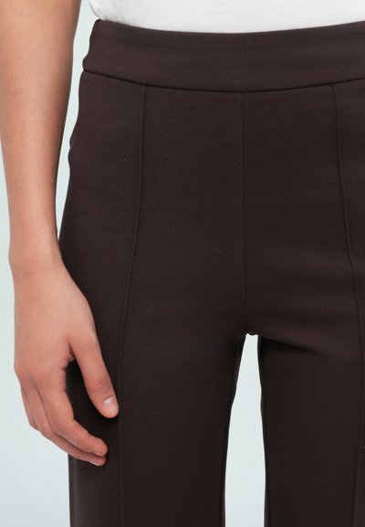 Braune dehnbare Stoffhosen mit hoher Taille und glatter Textur. Verfügt über genähte Vordernähte und eine taillierte Passform. Auf dem Bein platziert.