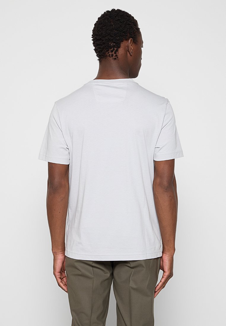 Camiseta de manga corta gris claro con cuello redondo, hecha de algodón suave, con un diseño liso y un pequeño detalle en la parte posterior del cuello.