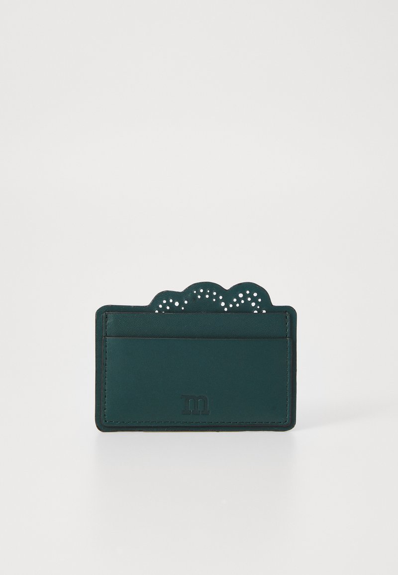 Porta-cartões em pele verde com uma parte superior em forma de onda, apresentando detalhes perfurados e um logótipo em relevo discreto na parte da frente. Dois slots para cartões visíveis.