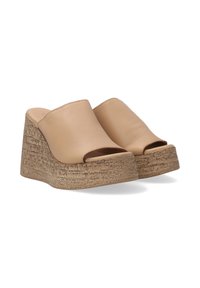 Beige wedge mules met een open teen en een gladde leren bovenzijde. Geweven kurkachtig materiaal vormt de wiggenhak.