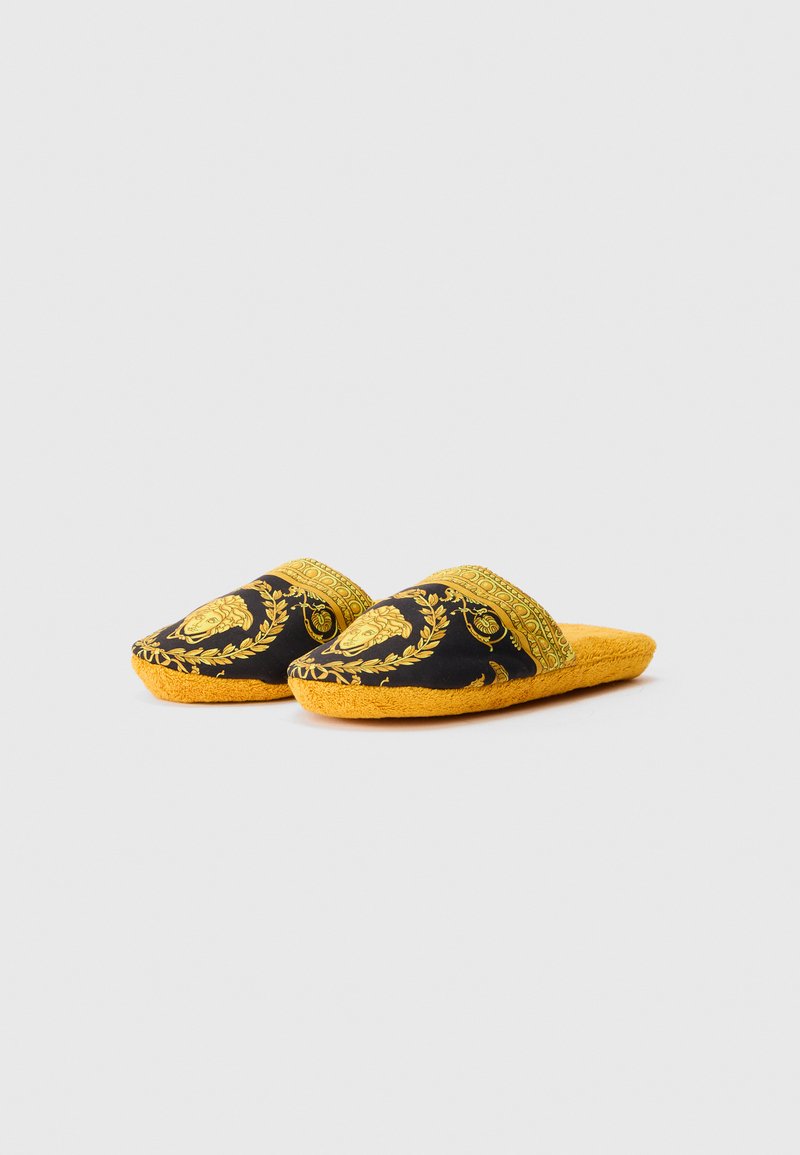 Slip-on slippers with golden baroque patterns and Medusa heads on black fabric upper, paired with golden yellow plush soles.