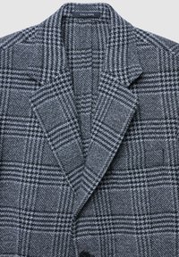 Blazer grigio a quadri con colletto a lappato, tessuto testurizzato e due tasche frontali. L'etichetta riporta "CALLIOPE." Presenta bottoni neri e una vestibilità sartoriale.