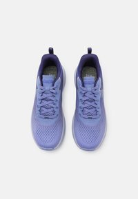 Baskets de sport violet clair avec une tige en maille, lacets plats, col rembourré et semelle texturée. Marque visible sur la languette.