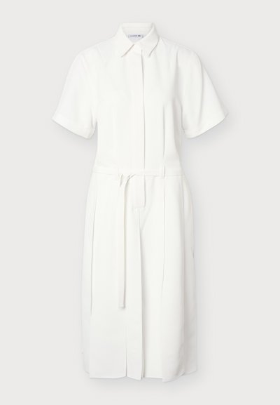 Robe chemise midi blanche à manches courtes avec col et ceinture amovible à la taille, avec patte de boutonnage frontale cachée.
