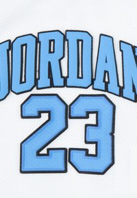 Λευκή αθλητική φανέλα με ανοιχτογαλανό περίγραμμα στο κείμενο "JORDAN" πάνω από τον αριθμό "23", και τα δύο κεντημένα με έντονα γράμματα τύπου block.