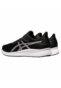 Black athletic shoes with a textured mesh upper, featuring white accents and branding. The sole is thick and cushioned for support.