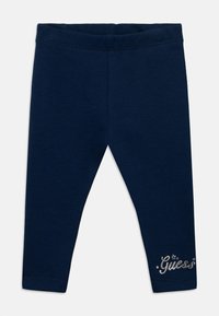 Leggings bleu marine en tissu extensible à la texture lisse, ornés d'un logo "Guess" argenté brodé à l'ourlet.