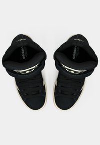 Μαύρα sneakers υψηλής κορυφής με επενδυμένο κολάρο, υφασμάτινο και συνθετικό επάνω μέρος, ενισχυμένη μύτη, λευκή σόλα και χρυσές λεπτομέρειες στις πλαϊνές πλευρές.