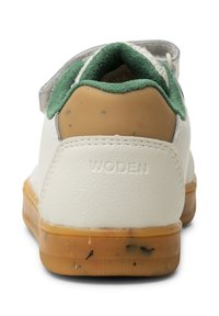 Sneaker bianca con accenti verdi, tomaia in pelle testurizzata, suola in gomma con squame visibili e collare imbottito per comfort.