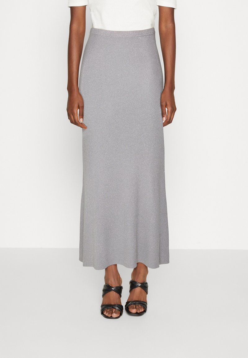 Falda maxi de punto acanalado gris con cintura ajustada y dobladillo fluido, combinada con sandalias negras de tiras retorcidas.