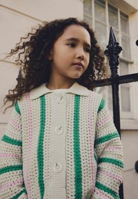Knitted cardigan with green, pink, and white stripes, featuring a collared neck and three large buttons. Soft texture, chunky design.