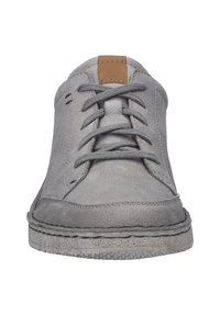 Šedá kožená sneaker s kulatou špičkou, texturovaným povrchem, šedými tkaničkami a hnědým koženým akcentem na jazyku. Podešev má prošívaný okraj.