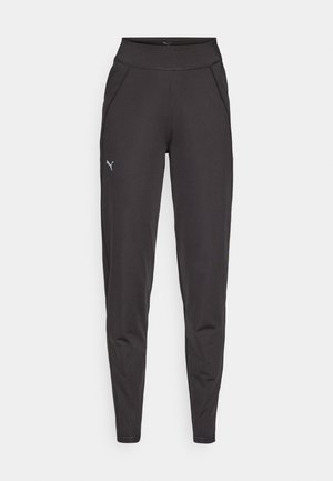 Fekete sportleggings rugalmas anyagból, magas derékkal, oldalsó zsebekkel és egy kis fényvisszaverő logóval a bal combján.