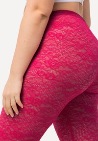 Rosa Spitzenleggings mit Blumenmuster, ausgestattet mit einem breiten Bund und transparenter Textur, die kunstvolle Details und lebendige Farben unterstreichen.