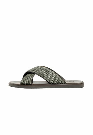 Sandale slide pour homme avec brides croisées en tissu tressé foncé et semelle plate marron sur fond blanc.